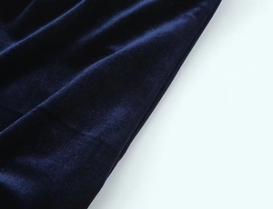 Detailed close-up of premium navy blue velvet fabric texture with soft drape and luster