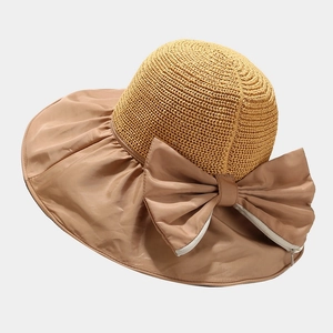 Detail of summer straw sun hat with large brim and decorative ribbon bow design
