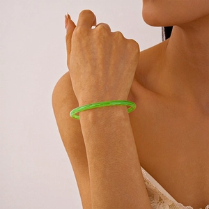 Gros plan d'un bracelet en acrylique vert translucide avec motifs marbrés sur un poignet