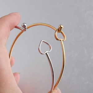 Detail of 2mm stainless steel open bangles with hollow heart and bead in gold and silver