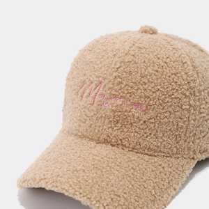 Dettaglio del ricamo Mama su un berretto da baseball in pile beige per autunno e inverno