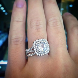 Detailed close-up of a princess cut rose gold ring with pink zircon on a woman's hand