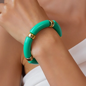 Primo piano di un bracciale a maglie grosse in acrilico verde menta e metallo dorato