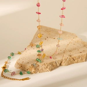 Detail of colorful natural stones on gold chain with S-STEEL tag and lobster clasp