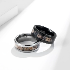 Detail view of black and silver tungsten rings with camo inlay on geometric props