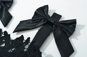 Detail of elegant black satin bow and intricate floral lace on sexy party dress