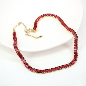 Macro detail of rectangle cut red rubies on a gold necklace with adjustable extension chain