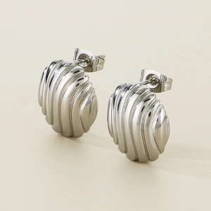 Macro detail of silver striped hollow stud earrings with minimalist vertical texture