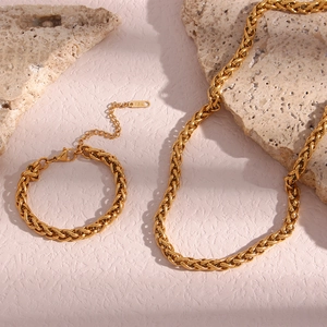 Detail of 18K gold plated 6mm basket weave chain necklace and bracelet on stone