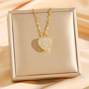 Collier élégant en titane doré avec pendentif cœur en cristaux sur un écrin