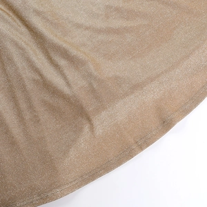 Close-up of champagne gold glitter fabric texture with metallic shimmer and fine stitching
