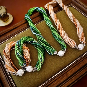 Detail of multi-strand braided crystal beaded necklaces with silver rhinestone clasps