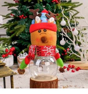 Detail of Christmas reindeer candy jar featuring a red hat, knit scarf, and clear storage