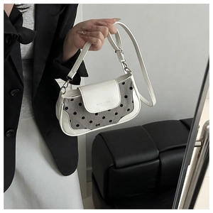 Détail du sac à pois blancs et gris avec coutures en cuir et gaufrage de mode