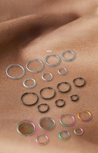 Three pairs of stainless steel hoop earrings in silver, black and rainbow multicolor