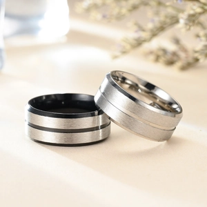 Detail of 8mm brushed stainless steel rings in silver and black with rose gold accents