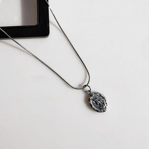 Close-up of gunmetal grey snake chain necklace with oval embossed mermaid portrait