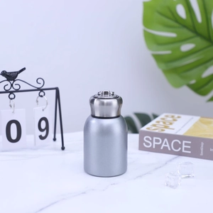 Mini silver 304 stainless steel vacuum flask with metal handle on marble surface