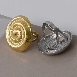 Macro view of gold and silver swirl rings featuring a vintage hammered metal texture