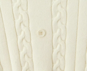 Gros plan détaillé du tricot torsadé crème avec motif et bouton en résine