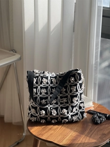Detailansicht der 3D-Blumenstickerei auf einer Vintage Canvas-Tragetasche in Schwarz-Weiß