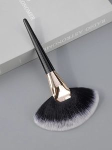 Detail of a large fan brush with dual-tone bristles and light gold metal ferrule