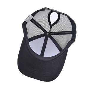 Internal view of black ponytail trucker hat showing mesh texture and 80% cotton wash label