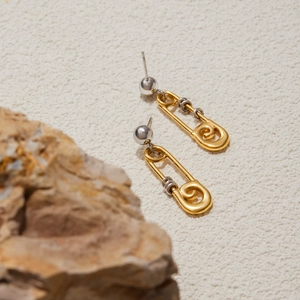 Vue macro de boucles d'oreilles trombone en or 18 carats avec fil d'argent sur pierre