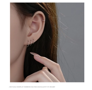 Close-up of minimalist S999 silver hoop earrings and ear cuff worn on model's ear