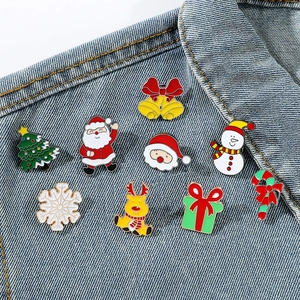 Christmas enamel brooch set featuring Santa, reindeer, and snowmen on denim jacket