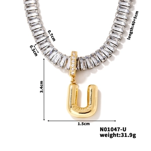 Close-up of gold plated letter U necklace with dimensions and zircon crystal details