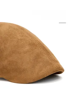 Detail of brown suede newsboy cap featuring a foldable brim and precision double stitching