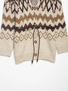 Close-up of knit cardigan with geometric jacquard patterns and sequin details