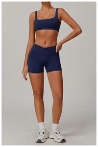 Detail der High-Waist Yoga-Shorts mit Überkreuz-Bund und dunkelblauem Sport-BH im Set