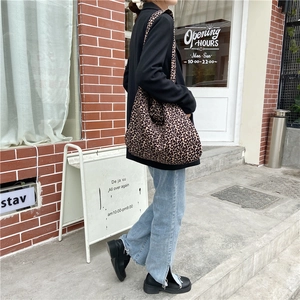 Detail of trendy leopard print canvas tote bag shown in a stylish outdoor street fashion setting