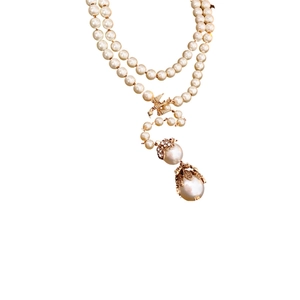 Vintage Y-shaped pearl necklace with gold bird flower accents and diamond details