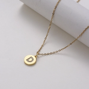 Gold stainless steel necklace with a zircon-inlaid letter D pendant on a white background