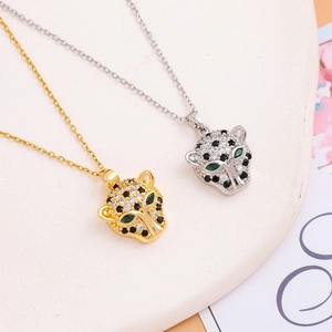 Iced out leopard head pendant necklace in gold and silver finish with green stone eyes