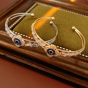 Vista macro dettagliata di bracciali aperti vintage con fiori in zircone oro e argento