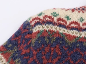 Nahaufnahme der Fair-Isle-Strickmuster mit roten, blauen und grünen Wollmischgarnen