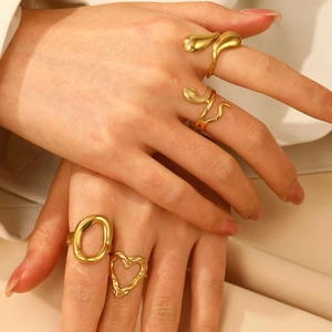 Detail of gold-plated rings with hammer texture heart and abstract snake design