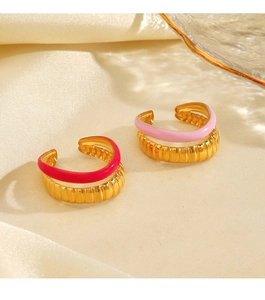 Close-up of stacked gold ribbed rings with vibrant fuchsia and soft pink enamel finish
