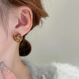 Close-up of vintage twisted hoop earrings in amber resin and gold plating on model