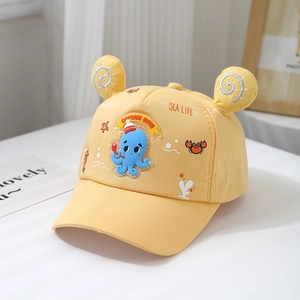 Close-up of yellow cotton toddler baseball cap featuring a cute blue octopus rubber patch
