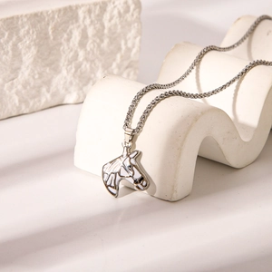 Detailed shot of horse head pendant with white enamel on a silver twisted chain