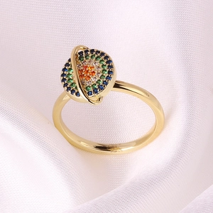 Macro view of gold Saturn ring featuring colorful pave crystals on white silk