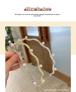 Detail of wavy gold and silver headbands with fine glitter texture and white pearls