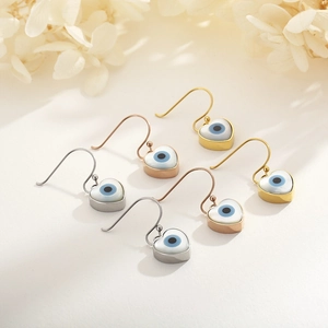 Heart-shaped evil eye dangle earrings in gold, silver, and rose gold finishes