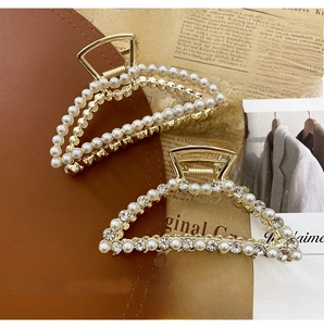 Detail of two gold metal hair claws with elegant pearls and sparkling rhinestones