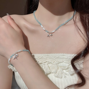 Détail du collier et du bracelet en perles océaniques avec pendentifs étoile et coquillage
